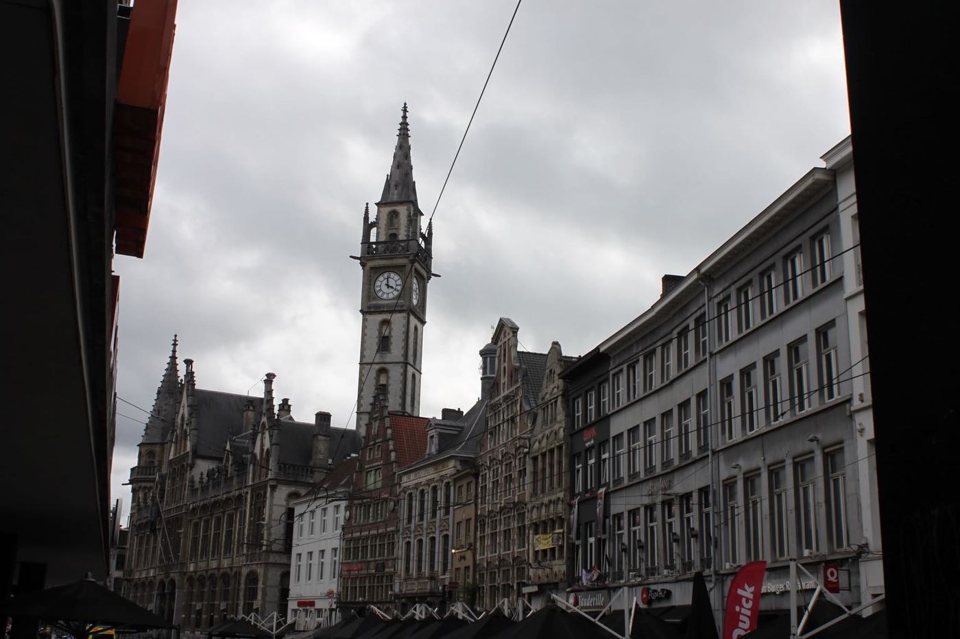 A clock tower above a row of old buildings