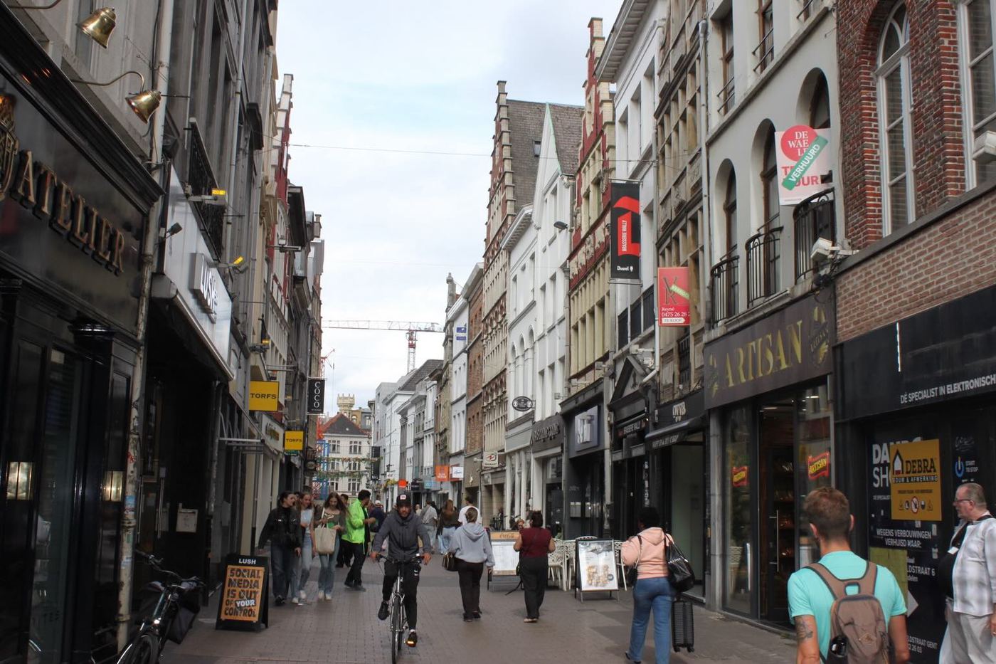 A cyclist on a busy shopping street
